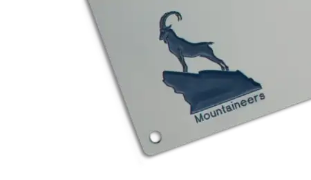 Filigrane, blau ausgelegte CNC-Gravur eines Steinbocks auf einem Felsen.